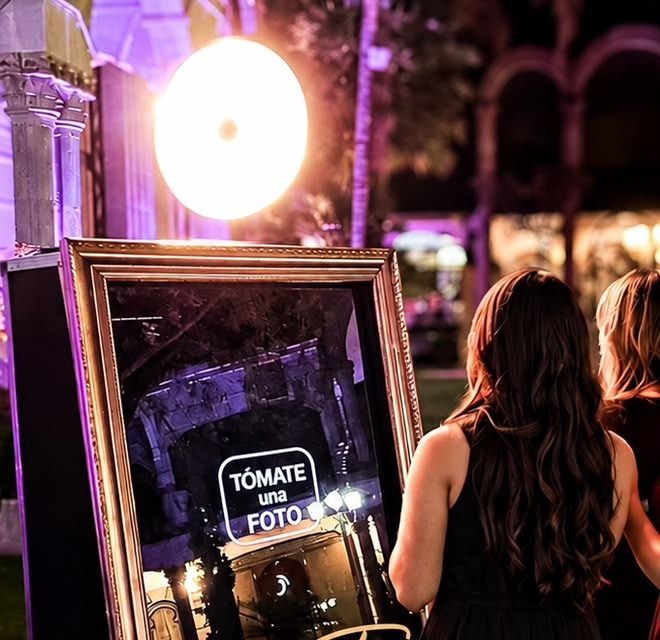 Invitadas en vestido largo frente al espejo mágico en jardín de hacienda iluminado en Querétaro