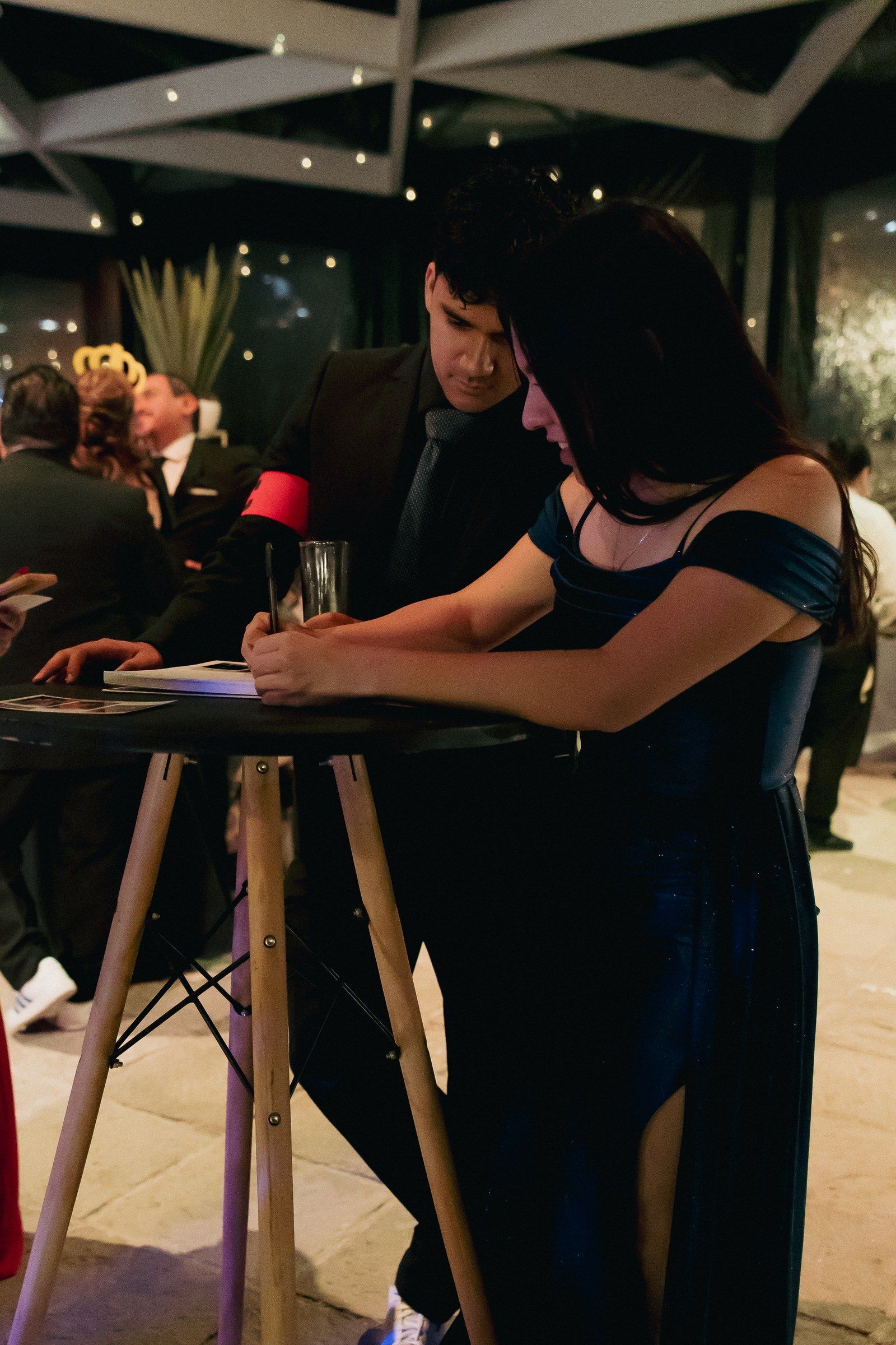 Pareja de invitados escribiendo un mensaje en el libro de firmas de Pikibooth durante una fiesta